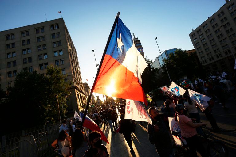 Fotografía de una bandera de Chile en manos de un protestante.